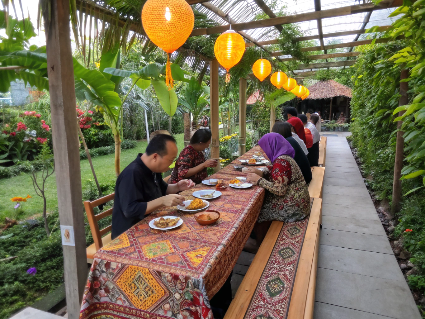 Communal long table dinner lit by lanterns outside community farm villa