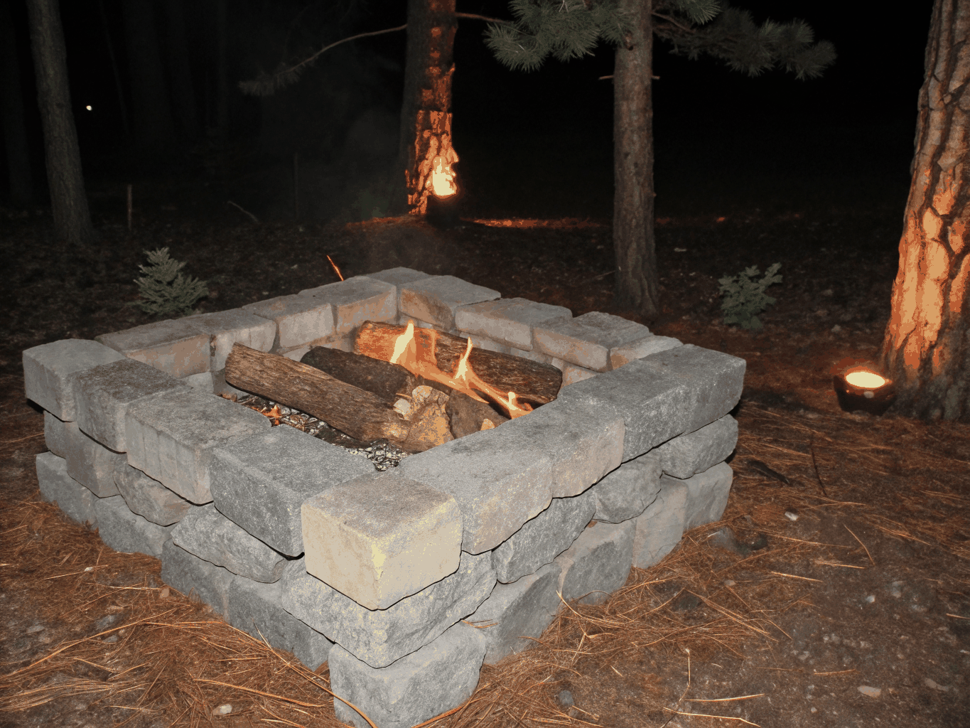 Gathering around an open stone fire pit beneath clear constellations